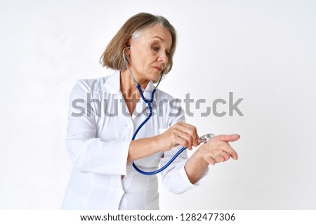 Female doctor in white coat create with stethoscope in hands                   