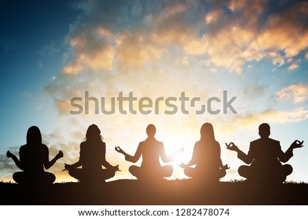 Silhouette Of People Doing Yoga Against Sky During Early Morning
