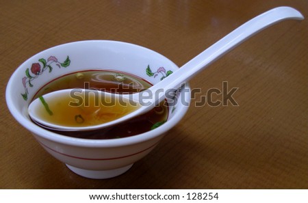 A Chinese bowl with soup and specific spoon