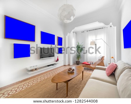 Blank picture template in a cozy stylish bright living room with natural ratan carpet, sofa, wooden table, plants and gallery on wall. Spacious modern interior in earthy colors with frame mockup
