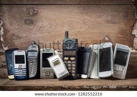 Old and obsolete mobile phone or cell phones on space of old wood background Royalty-Free Stock Photo #1282552216