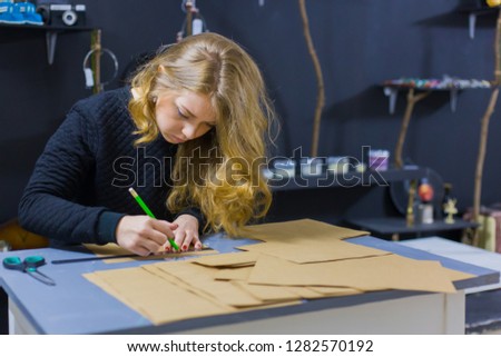 Professional woman decorator, designer working with kraft paper and making envelope at workshop, studio. Design, handmade and art concept