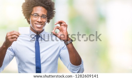 Afro american man holding visit card over isolated background doing ok sign with fingers, excellent symbol