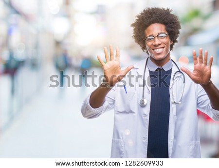 Afro american doctor man over isolated background showing and pointing up with fingers number ten while smiling confident and happy.