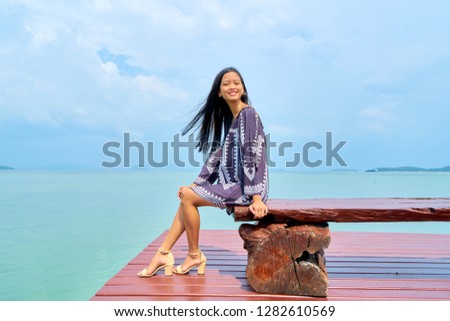 Beautiful woman posing - side view sitting on bench and enjoying