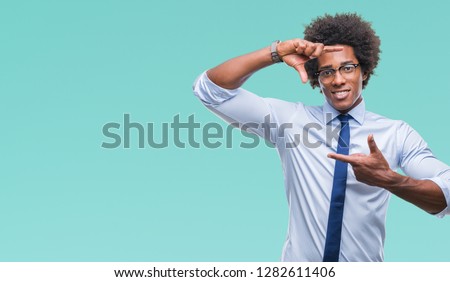 Afro american business man wearing glasses over isolated background smiling making frame with hands and fingers with happy face. Creativity and photography concept.