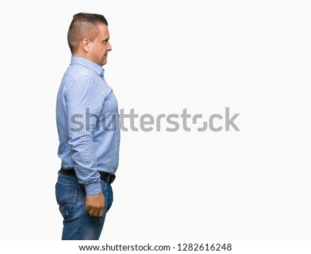 Middle age arab business man over isolated background looking to side, relax profile pose with natural face with confident smile.