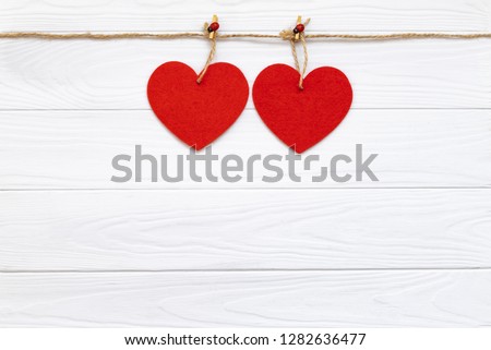 red fabric hearts on wooden white background, love concept