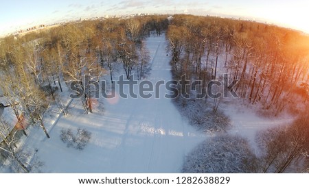 Winter photo with drone. View of the park from above. The quadcopter takes off a sunny winter day. Aerial photography