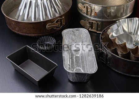 Molds for baking cakes in the home kitchen. Old dusty kitchen accessories. Dark background.