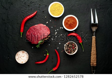 
meat from a butcher shop, steak with ingredients. A piece of beef on a concrete black background