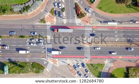 Top down aerial footage of traffic on a busy Junction with cars and trucks.