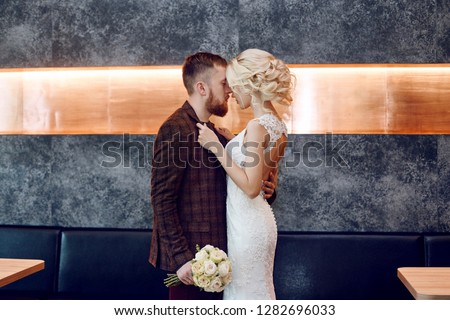Couple in love hugs and kisses on their wedding day. Hipster groom and the bride, love and loyalty. Ideal couple is preparing to become husband and wife. Man and woman looking at each other close up