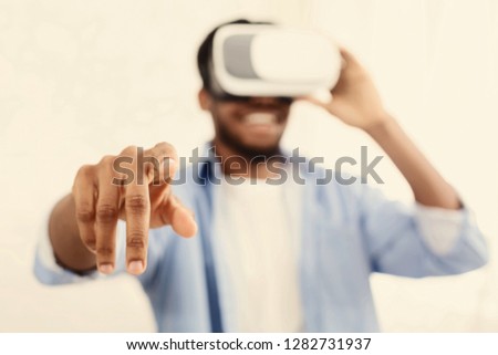 Virtual reality. Excited african-american man in vr goggles pushing invisible button, copy space