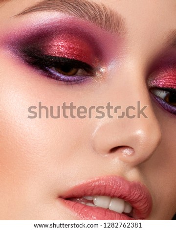 Closeup portrait of young beautiful woman with bright pink smokey eyes and lips. Fashion makeup. Studio shot. Modern summer make up. Extreme closeup, partial face view