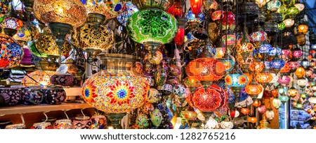 Beautiful lamps in Grand Bazaar, Istanbul, Turkey. Panoramic view of colorful oriental gifts. Stained glass lamps in artisan market close-up. Nice Arab and Turkish craft products in eastern bazaar.