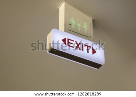 Transport Concept. Close up of exit and vacant toilet/restroom sign on airplane ceiling