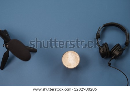 Flat lay composition with Headphones, microphone and coffee on a blue background. Podcast or webinar concept.