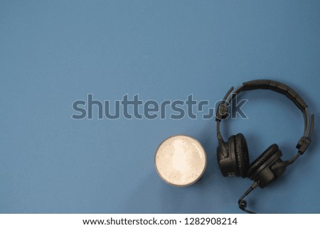 Flat lay composition with Headphones, microphone and coffee on a blue background. Podcast or webinar concept.