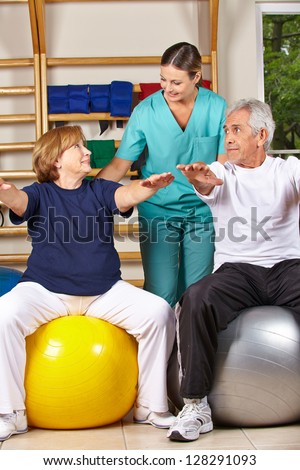 Two senior people doing back fitness training with physiotherapist