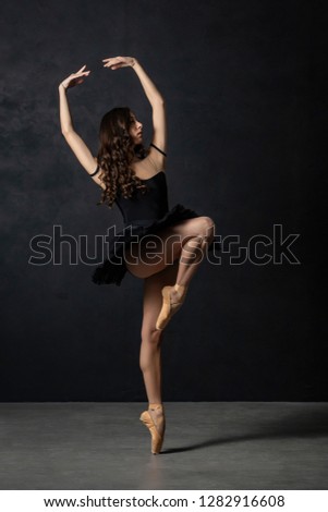 ballerina dancer dancing on the toes indoor with balck background