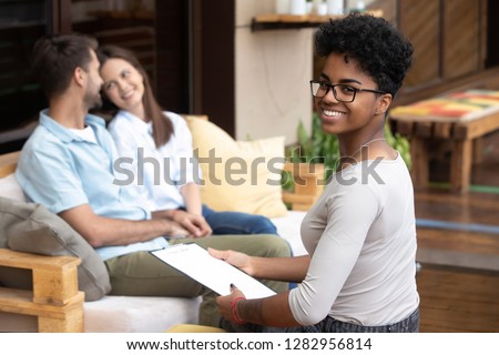 Happy married couple young spouses sitting on sofa holds hands visit medical professional marriage family therapists counsellor. Doctor feels glad to help patients she smiling posing looking at camera Royalty-Free Stock Photo #1282956814