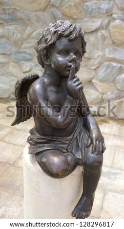 Cupid statue sitting made from black marble stone