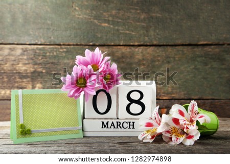 Wooden cube calendar with greeting card and flowers