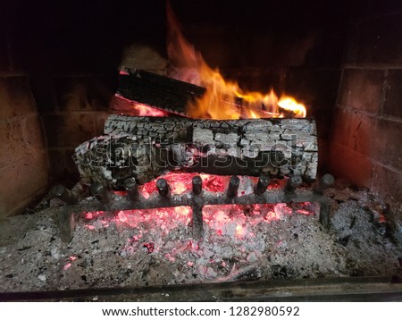 A  warm cozy fire is a brick fireplace.