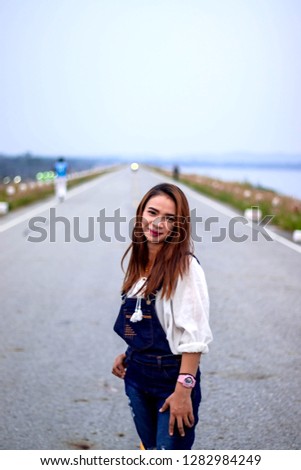 Asian women on holiday Women wear white shirts Dungarees Women Portrait Photography on the road.