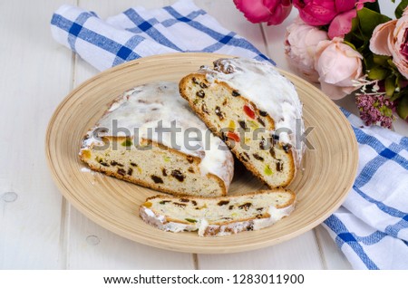 Baked cake with raisins and candied fruits, sprinkled with powdered sugar. Studio Photo