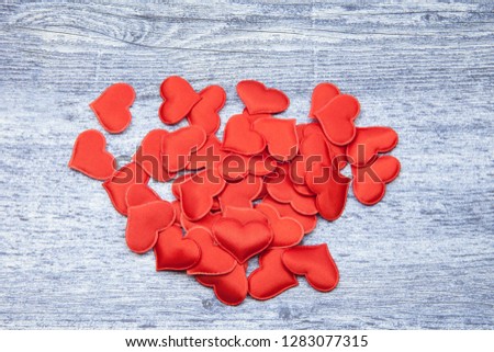 Red hearts on a wooden jeans color background, concept of love and loyalty