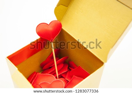 Many red hearts in a gift box, one heart on a stick