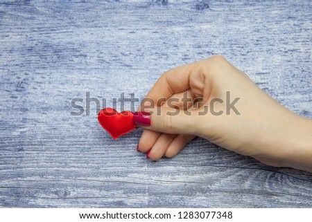 Red heart and female hand holding it, concept of eternal love