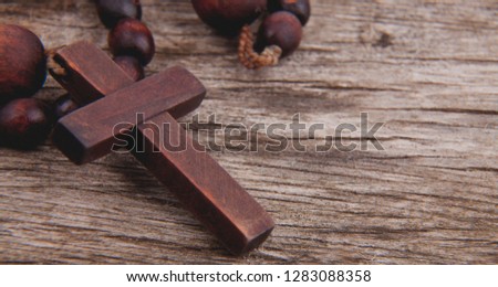 Close up rosary against wooden board background as symbol of salvation and eternal life. Religion tradition. 