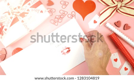 Happy Valentine's Day overhead flat lay wrapping gift and writing cards with lens flare.