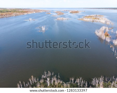 Aerial photo of the lake in the forests with big mountains. Lake with small islands