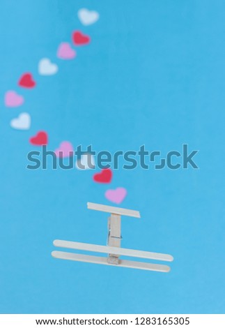 Little Wooden Airplane Trailing Red, White and Pink Hearts Valentine Concept Depth of Field