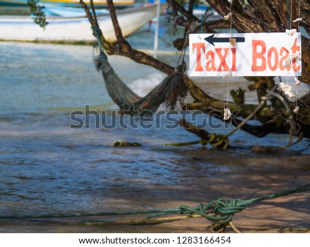 Taxi boat sign hang on a tee at beach near the sea for tourists going somewhere around the island.