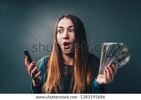 Young attractive woman showing sincere excitement about victory in online lottery. Girl being happy winning a bet in online sport gambling application on her mobile phone. 