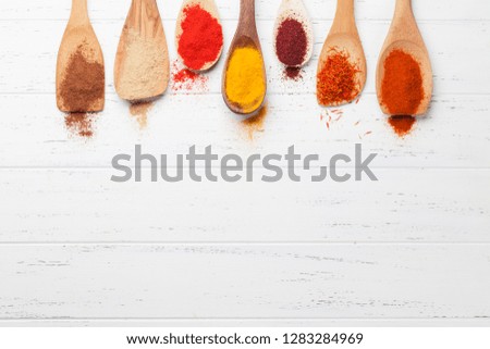 Set of various spices in spoons on wooden background. Top view with space for your recipe. Flat lay