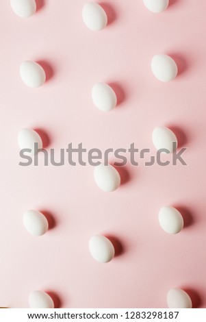 White eggs on a light pink background with reflection of the shadows and copy space. layout to easter. Flat lay, pattern
