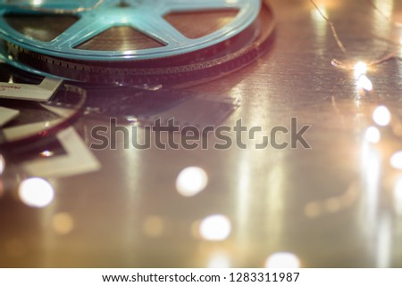 Photo slides, film negatives and 8mm or super 8 vintage film reel on a wood table with soft lights.