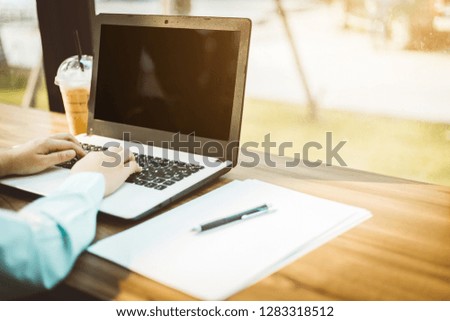 Close-up of Business female working with laptop coffee in coffee shop like the background.