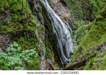 Waterfall at rocks with moss in the mountains while hiking