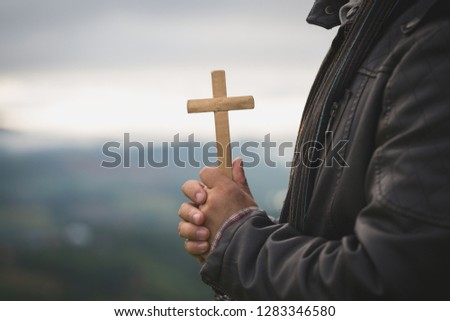 Human hands holding a cross holy and prayed for blessings from God,  Amour Worship God concept. - Image