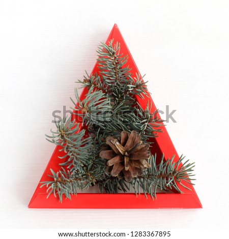 spruce branches and cone in red triangular edging top view . sign of decorative Christmas tree