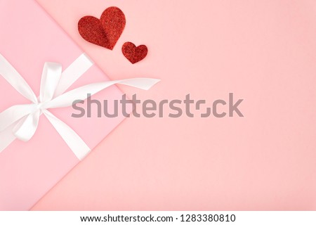 Decoration valentine's day on table top view  background. Flat lay composition of red shape heart and pink gift box with white ribbon coral paper background for mockup your design. Love day concept.
