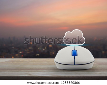 Cloud icon with copy space and wireless computer mouse on wooden table over blur of cityscape on warm light sundown, Cloud computing concept