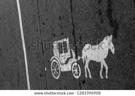 Vintage old horse carriage painted transportation sign on asphalt road in city of Kuala Lumpur